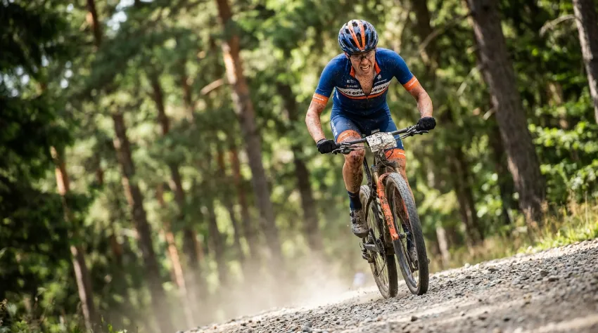 XC kolesar med hitrim vzponom po makadamu