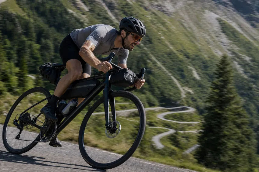 Kolesar med močnim pritiskom na pedala na strmem vzponu